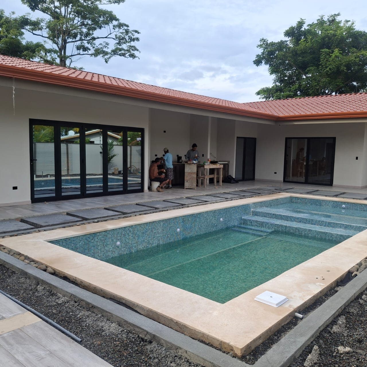 Feature pool with integrated spa under construction, gray mosaic tile